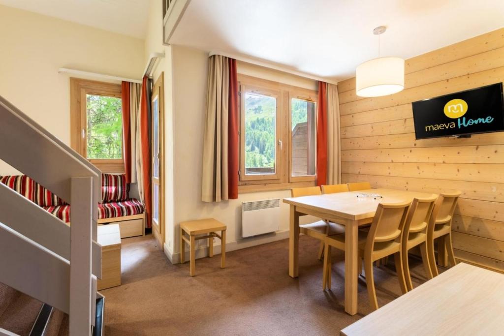 comedor con mesa y sillas en Résidence Plagne Lauze - maeva Home - Appartement 3 Pièces 7 Personnes - Pr 44 en Mâcot La Plagne