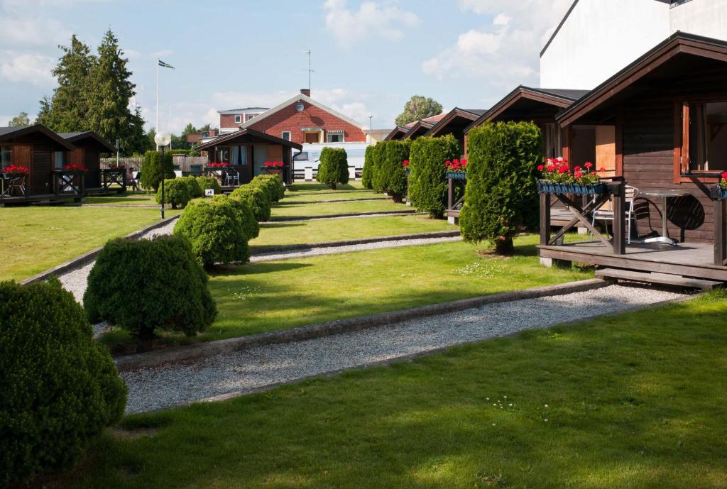 a garden of houses with bushes and flowers at Hotell Milano in Åstorp
