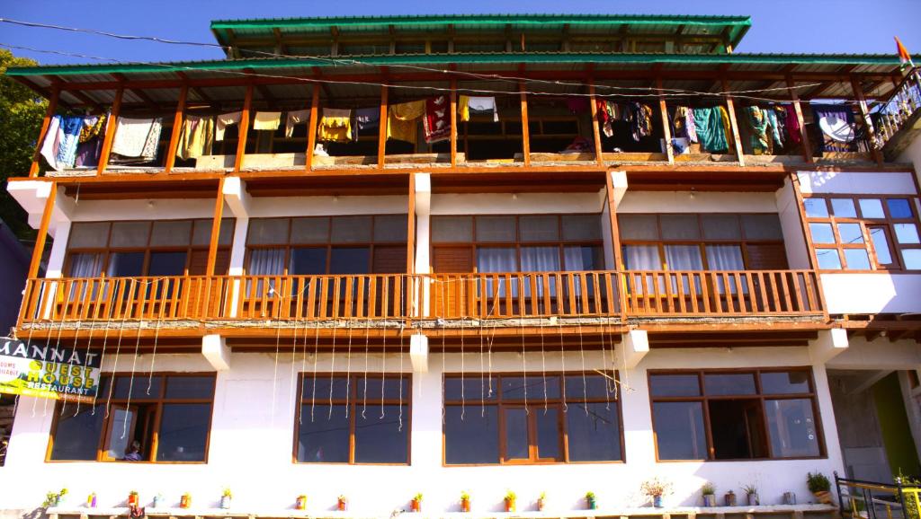 um edifício com uma varanda com roupa a secar em Hotel Mannat Sach Pass em Tisa