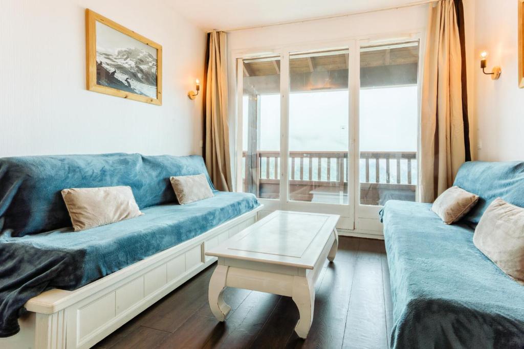 un salon avec un canapé bleu et une table dans l'établissement Résidence Le Thabor - maeva Home - Appartement 2 Pièces 5 Personnes - Confort MAE-6374, à Le Désert