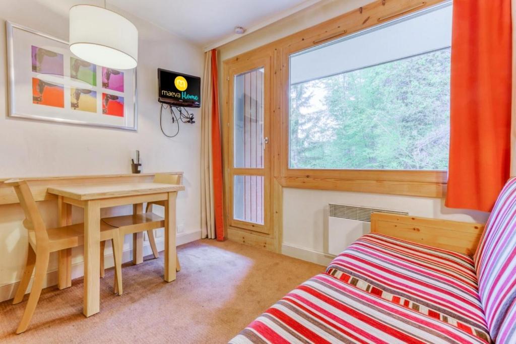 - un salon avec un bureau, une table et une fenêtre dans l'établissement Résidence Plagne Lauze - maeva Home - Studio 2 personnes - Sélection MAE-9201, à Mâcot La Plagne