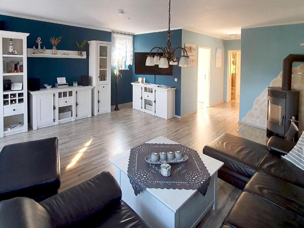 ein Wohnzimmer mit einem Sofa und einem Tisch in der Unterkunft Reethaus Zickersche Berge - WG 02 mit Kamin und Terrasse in Gager