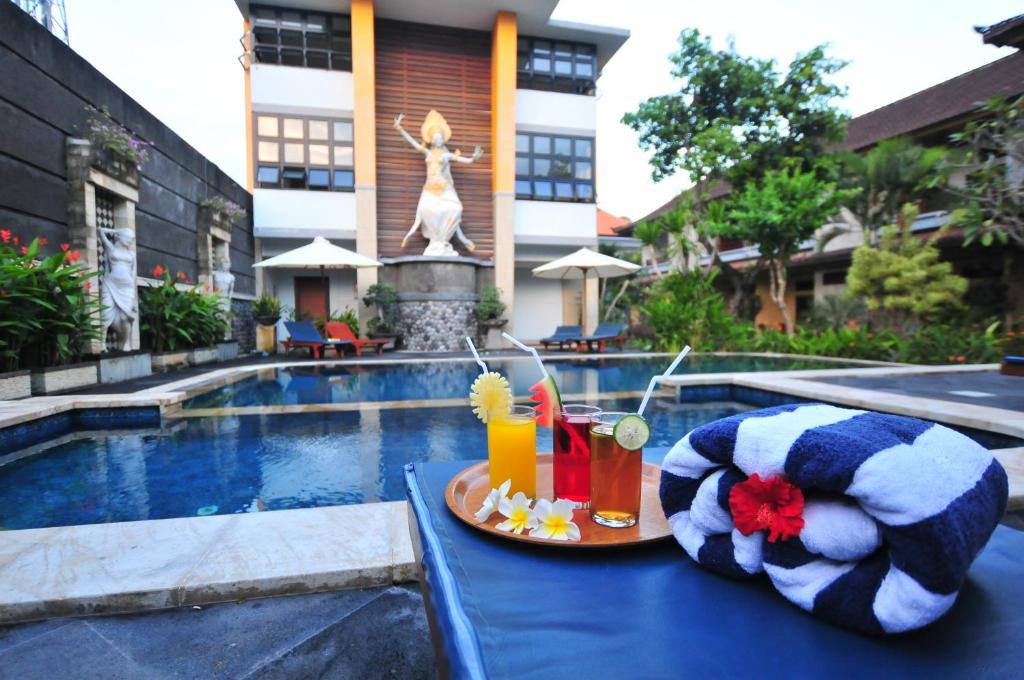 a table with a tray of food and drinks next to a pool at Sandat Hotel Legian in Legian