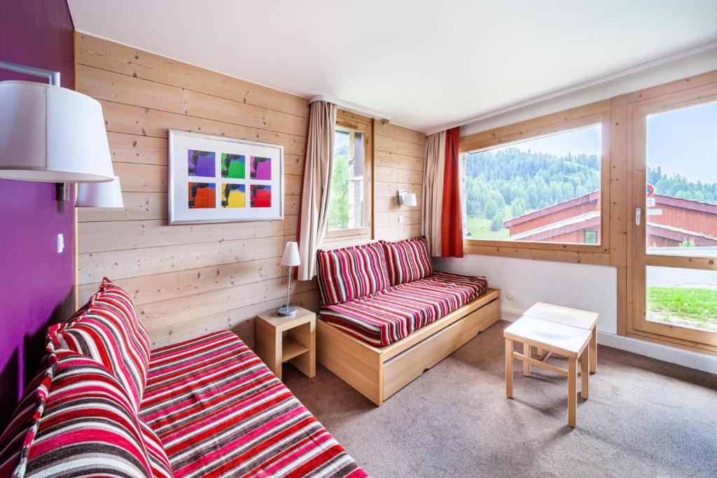 un salon avec un canapé et une fenêtre dans l'établissement Résidence Plagne Lauze - maeva Home - Appartement 2 Pièces 5 Personnes - Prestige MAE-0144, à Mâcot La Plagne