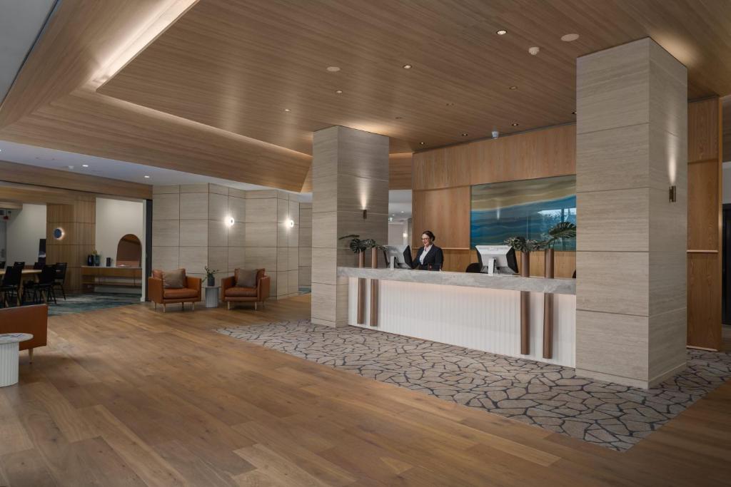 a lobby with a man sitting at a reception desk at Rydges Geelong in Geelong