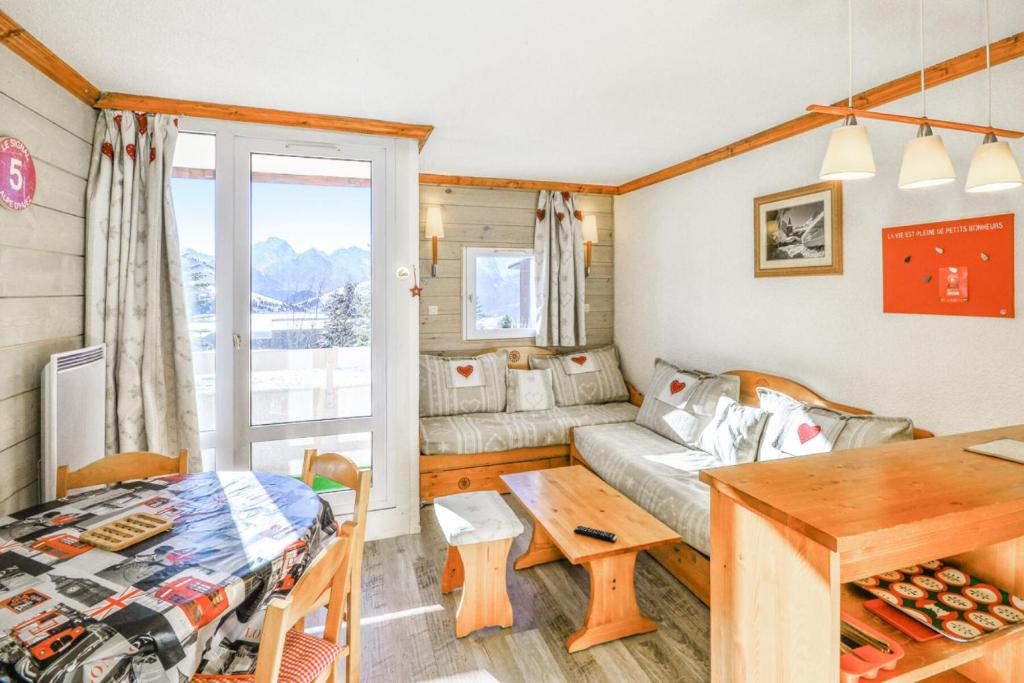 un salon avec un canapé et une table dans l'établissement Résidence Les Horizons d'Huez - maeva Home - Studio 4 personnes - Sélection MAE-4178, à Huez