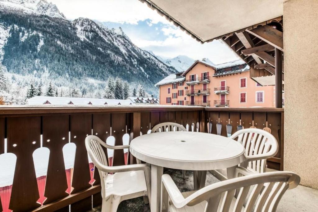 einen Tisch und Stühle auf einem Balkon mit schneebedeckten Bergen in der Unterkunft Résidence La Ginabelle - maeva Home - Appartement 3 pièces 6 personnes - P 604 in Chamonix-Mont-Blanc