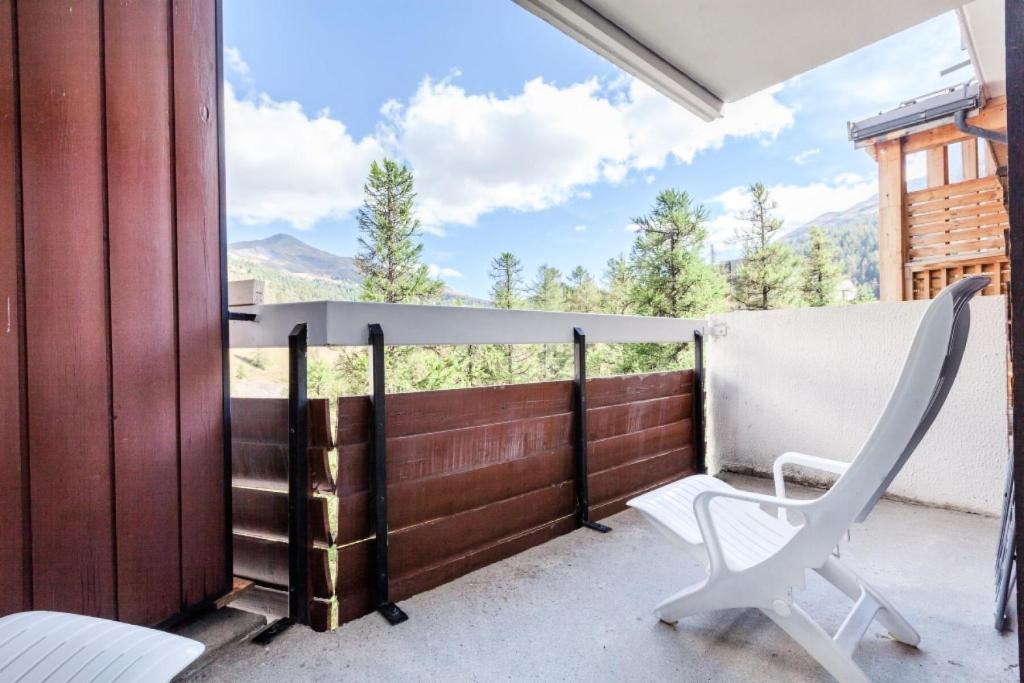 une chaise blanche sur un balcon avec vue dans l'établissement Résidence L'Eyssina - maeva Home - Appartement 2 Pièces 6 Personnes - Budget MAE-1420, à Vars