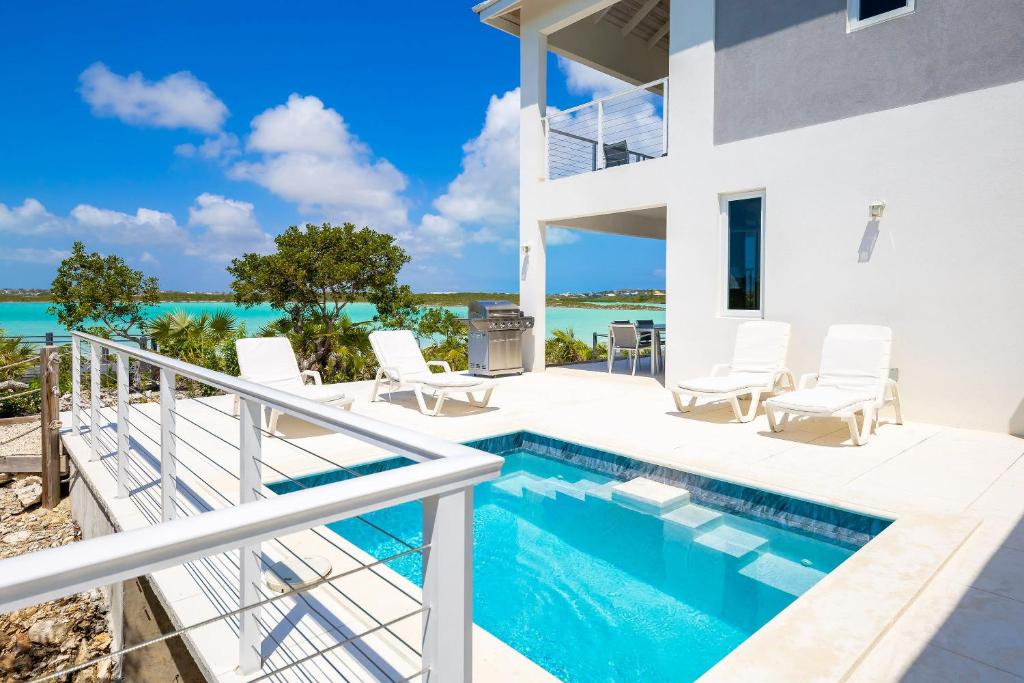 a house on the beach with a swimming pool at NEW Tropical Waterfront Cooper Jack Bay Villas in Five Cays Settlement