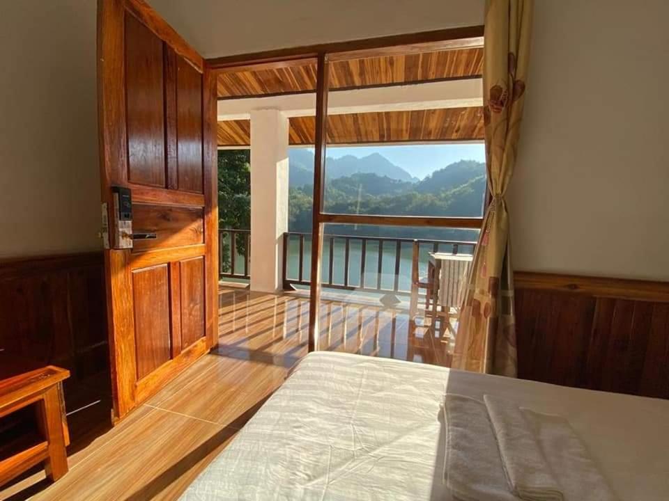 a bedroom with a bed and a balcony with a view at Nongkhaiw river view in Nongkhiaw