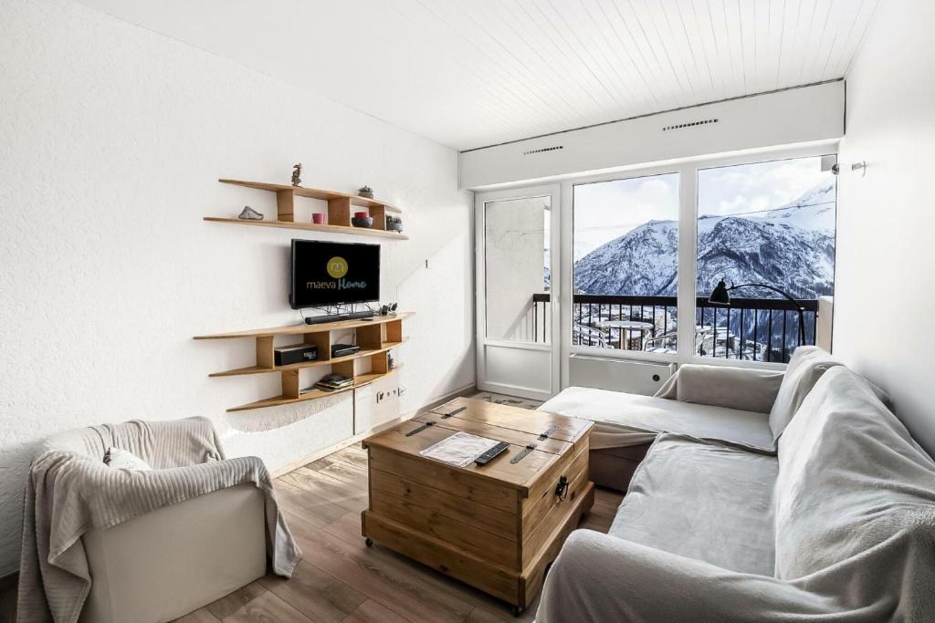 un salon avec un canapé et une grande fenêtre dans l'établissement Résidence Le Christiana - maeva Home - Appartement 2 pièces 6 personnes - Prestige MAE-8614, à Orcières