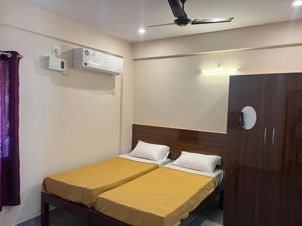 a bedroom with two beds and a mirror at Rt Service Apartments Hotel in Velankanni