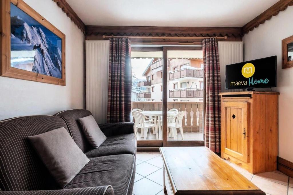 ein Wohnzimmer mit einem Sofa und einem Tisch in der Unterkunft Résidence La Ginabelle - maeva Home - Appartement 3 pièces 6 personnes - P 904 in Chamonix-Mont-Blanc