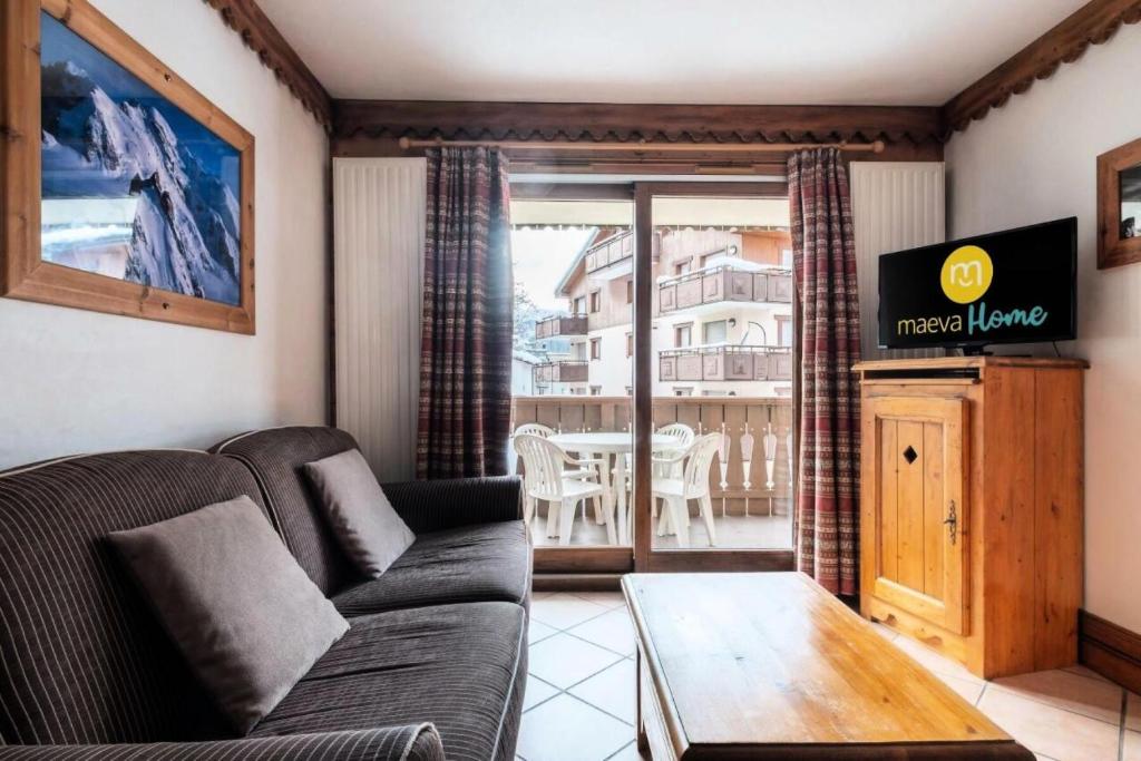 un salon avec un canapé et une table dans l'établissement Résidence La Ginabelle - maeva Home - Appartement 3 pièces 6 personnes - Prestige MAE-4054, à Chamonix-Mont-Blanc