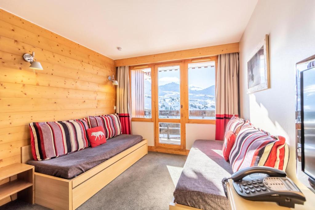 une chambre avec deux lits et une fenêtre dans l'établissement Résidence Les Néreïdes - maeva Home - Appartement 3 pièces 7 personnes - Prestige MAE-2704, à La Plagne Tarentaise