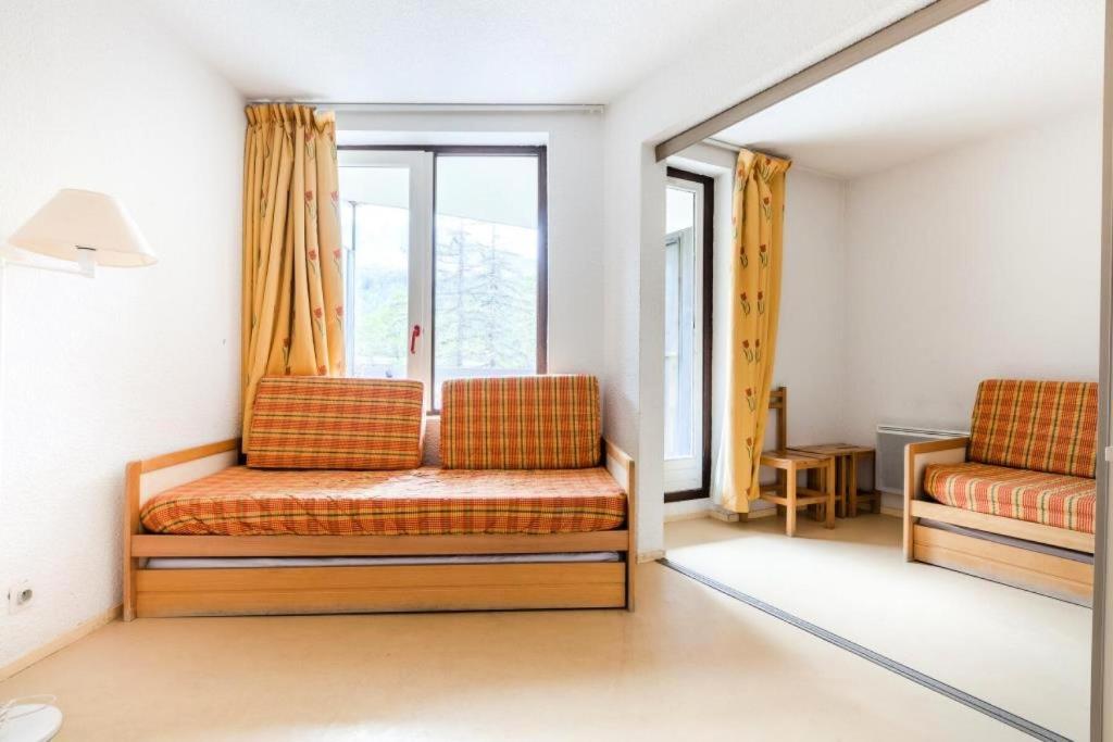 ein Wohnzimmer mit 2 Stühlen und einem Fenster in der Unterkunft Résidence L'Eyssina - maeva Home - Studio 6 Personnes Budget 48 in Vars
