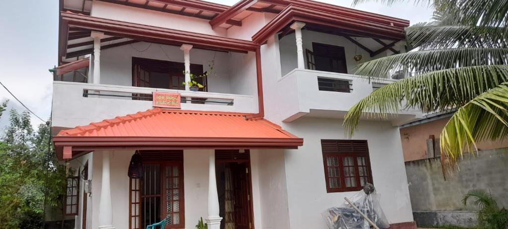 Biały dom z czerwonym dachem w obiekcie Chathu Home Stay w mieście Ambalangoda
