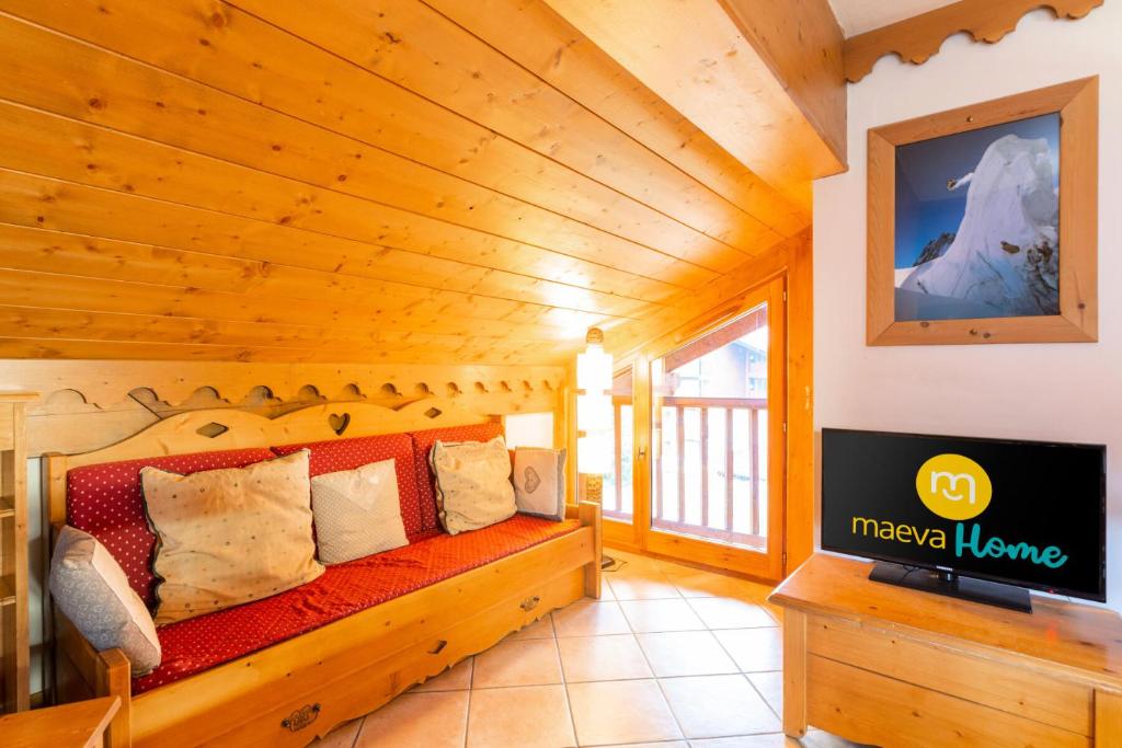 ein Wohnzimmer mit Sofa und Fernseher in der Unterkunft Résidence Les Fermes du Soleil - maeva Home - Appartement 3 pièces 5 personnes - Sélection MAE-9504 in Les Carroz d'Araches