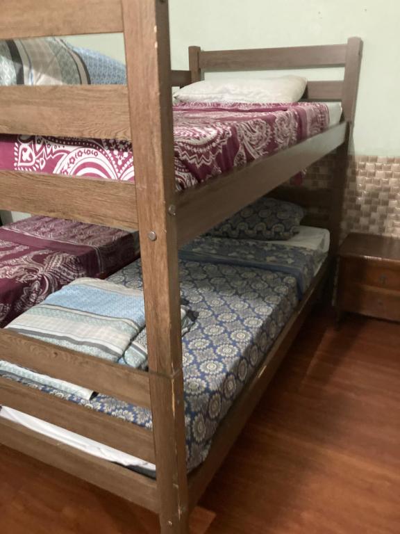 a wooden bunk bed with colorful blankets and pillows at N4 1 Casa Céntrica Próxima al Puente Internacional de la Concordia in Artigas