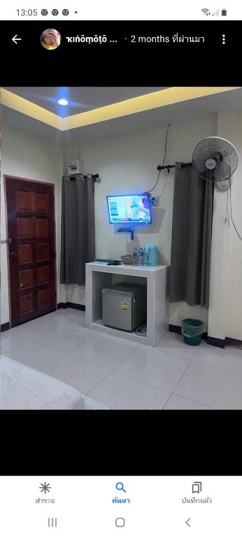 sala de estar con TV y mesa en รีสอร์ท ตลาดไทร0819770216, en Ban Tha Suan Ya