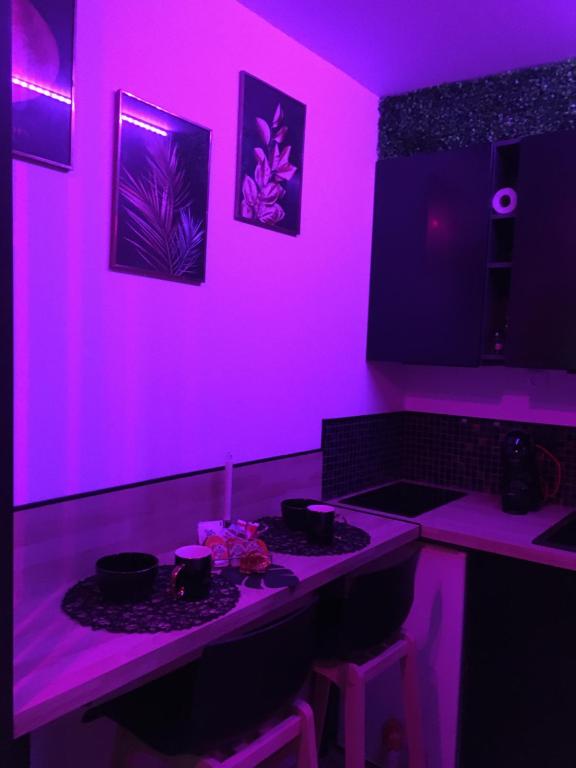 a kitchen with pink lighting and a counter with a stove at Heavenly Love in Yvetot