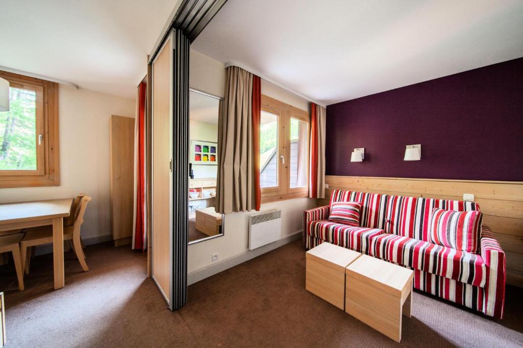 un salon avec un canapé rouge et une table dans l'établissement Résidence Plagne Lauze - maeva Home - Studio 4 personnes - Budget MAE-6804, à Mâcot La Plagne