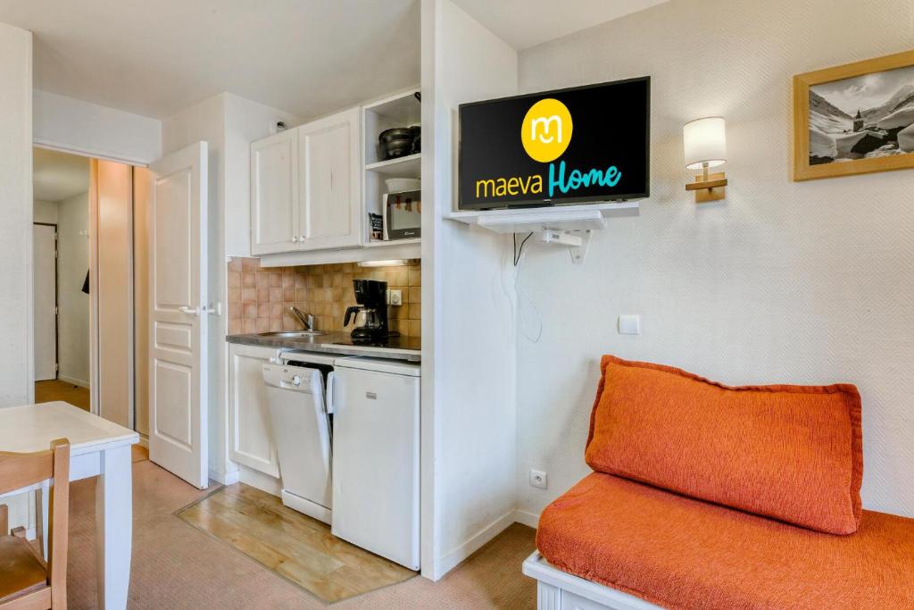 a living room with a couch and a kitchen at Résidence Quartier Falaise - maeva Home - Appartement 2 Pièces 5 Personnes - Sélection MAE-6534 in Avoriaz