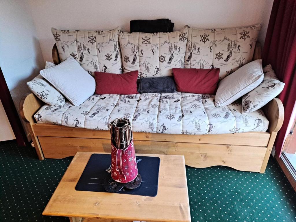 un canapé avec des oreillers et une table dans une pièce dans l'établissement Résidence Les Sentiers du Tueda - maeva Home - 2 Pièces 4 Personnes Confort MAE-4845, à Les Allues