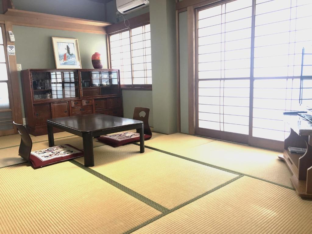 una sala de estar con mesa en una habitación con ventanas en 今市STAY - NIKKO private house rental only 5 min to station en Nikko