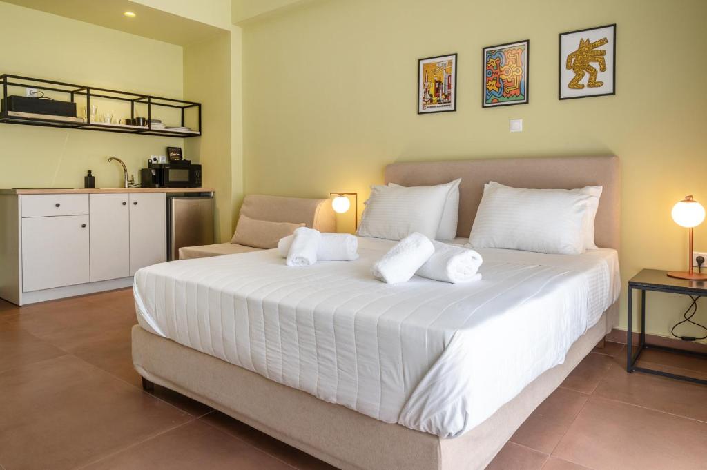 1 dormitorio con 1 cama blanca grande y cocina en ATHENS STORIES, en Atenas