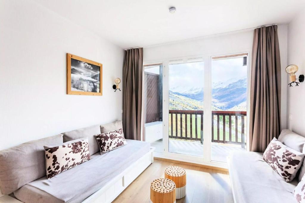 un salon avec un canapé et une grande fenêtre dans l'établissement Résidence Le Thabor - maeva Home - Appartement 2 Pièces 5 Personnes - Sélection MAE-4741, à Le Désert