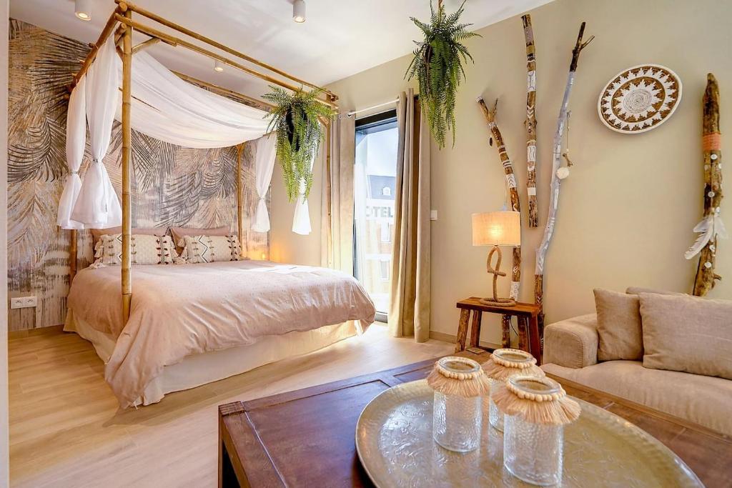 sypialnia z łóżkiem z baldachimem i kanapą w obiekcie La Bohème w mieście Liège