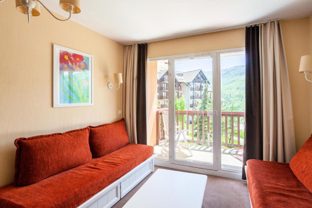 un salon avec un canapé et une grande fenêtre dans l'établissement Résidence Le Thabor - maeva Home - Appartement 3 pièces 7 personnes Confort MAE-2204, à Le Désert