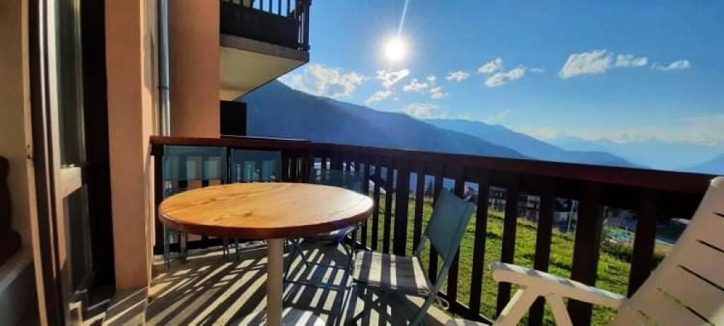 a balcony with a wooden table and a view of mountains at Résidence Le Thabor - maeva Home - Appartement 2 pièces 5 personnes Sélect 71 in Le Désert