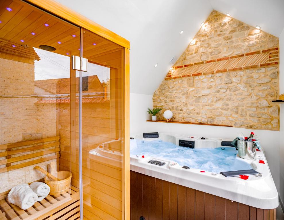 a jacuzzi tub in the corner of a bathroom at Escapade au Cocon des Plaisirs Secrets Spa &Sauna 