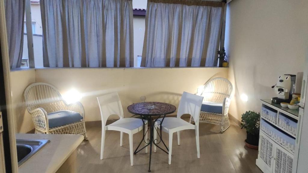 - une cuisine avec une table, des chaises et un évier dans l'établissement Brezza Marina, à Isola delle Femmine