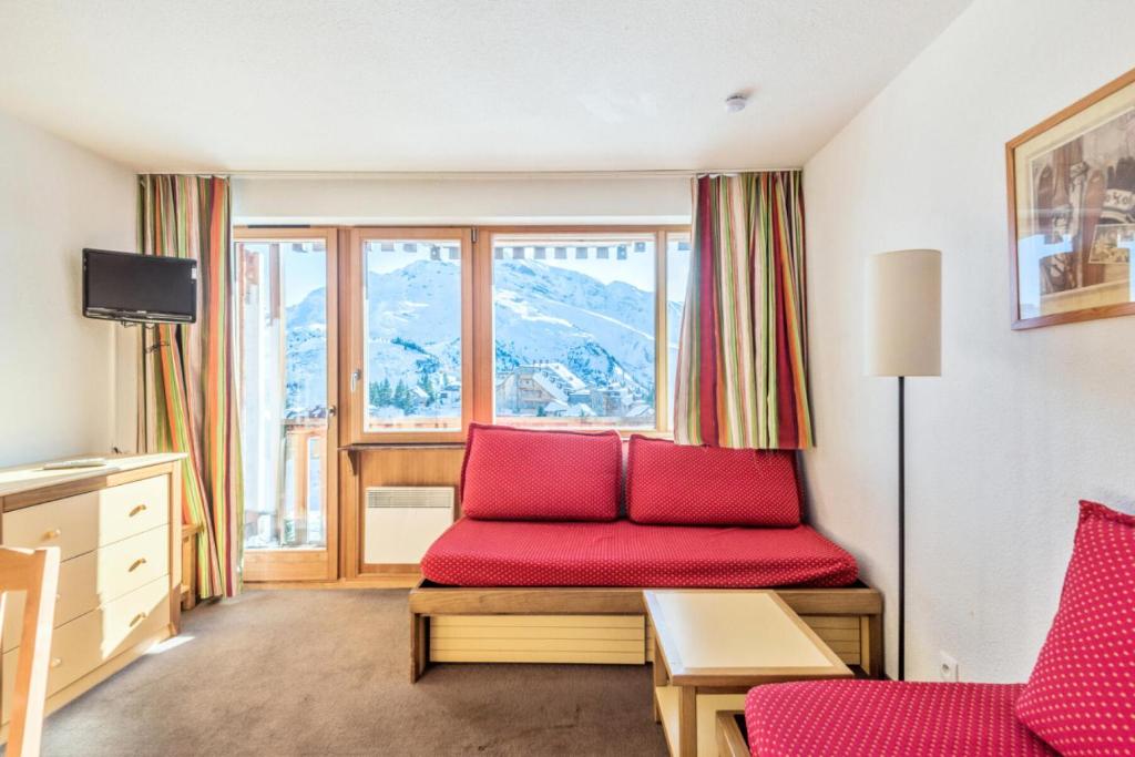 - un salon avec un canapé rouge et une fenêtre dans l'établissement Résidence Les Fontaines Blanches - maeva Home - Appartement 2 pièces 7 personnes - Confort MAE-5103, à Morzine