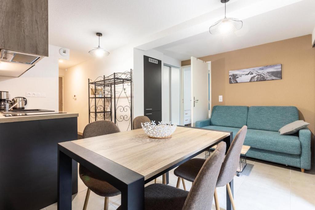 une cuisine et une salle à manger avec une table et des chaises dans l'établissement Résidence les Chardons - maeva Home - Appartement 2 pièces 5 personnes - Confort MAE-4014, à Arc 1800