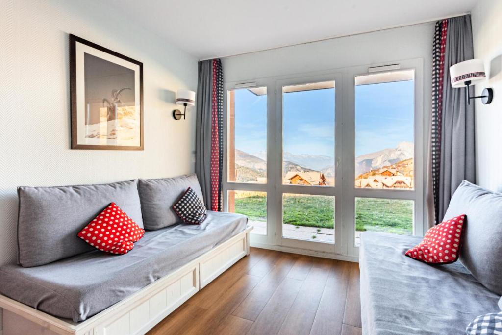 un salon avec un canapé et une fenêtre dans l'établissement Résidence Le Thabor - maeva Home - Appartement 2 pièces 5 personnes - Confort MAE-0294, à Le Désert