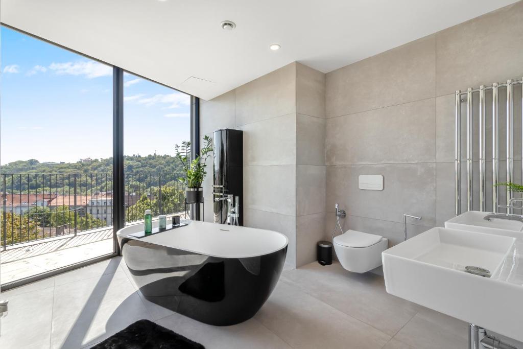 a bathroom with a tub and a sink and a toilet at Luxury Penthouse Prague in Prague