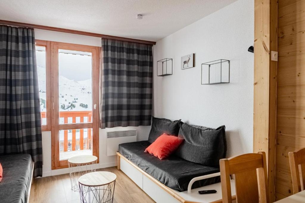 un salon avec un canapé et une fenêtre dans l'établissement Résidence Les Constellations - maeva Home - 2 Pièces 5 personnes Sélection MAE-7324, à La Plagne Tarentaise