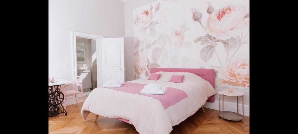 um quarto com uma cama e uma parede rosa e branca em La Parenthèse Fléchoise, Chambre Agathe em La Flèche