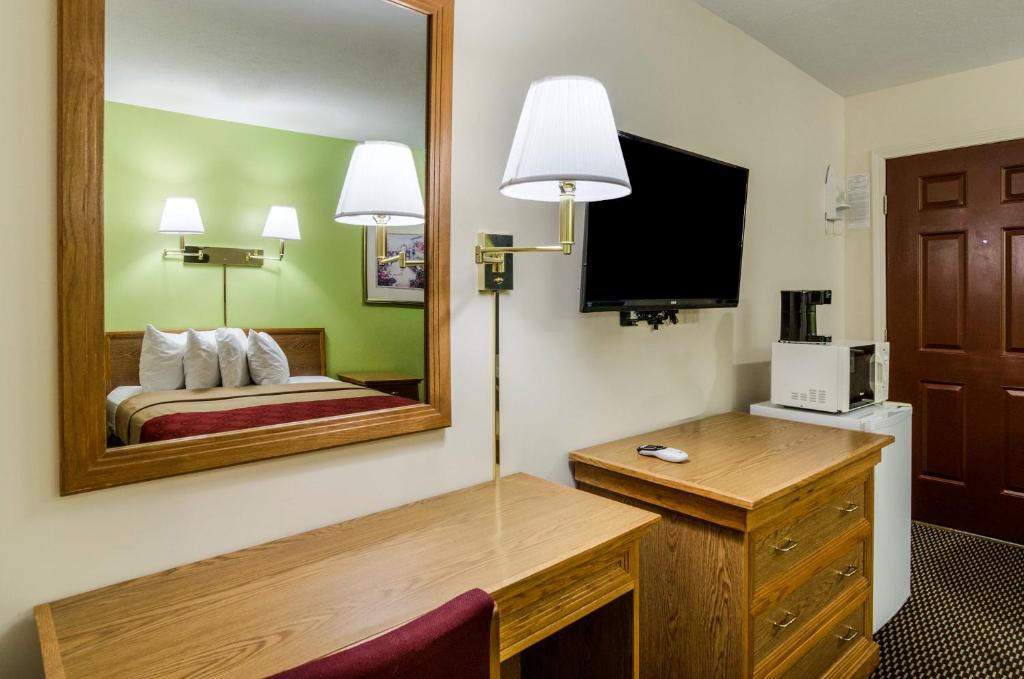 a hotel room with a bed and a mirror at Econo Lodge University in Lawrence