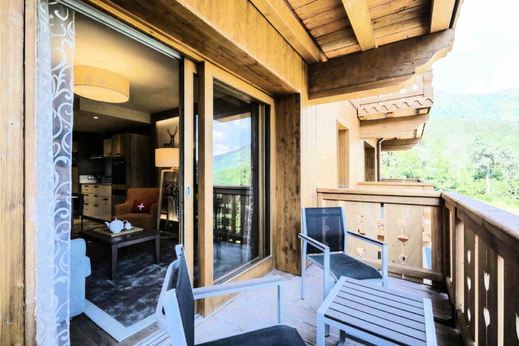 Les AlluesにあるRésidence Premium L'Hévana - maeva Home - Appartement 2 pièces 4 personne 044のバルコニー(椅子2脚、テーブル付)、窓が備わります。