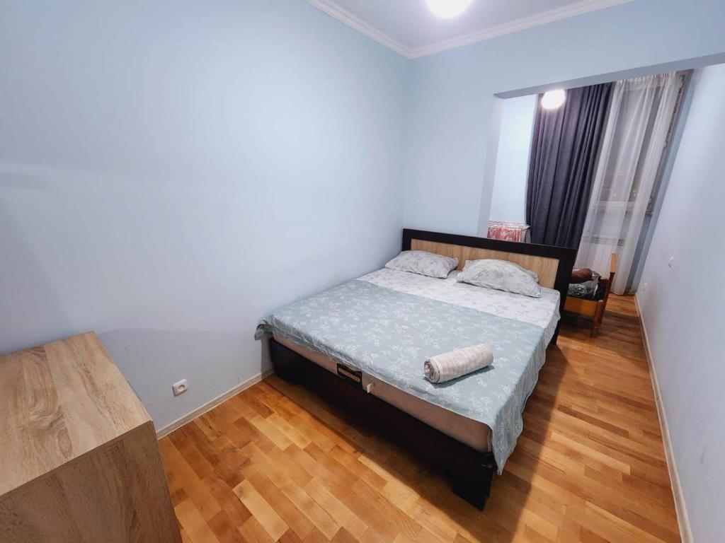a bedroom with a bed and a wooden floor at Deluxe Spacious Apartment with 1 bedroom , New building, Near City Center in Yerevan