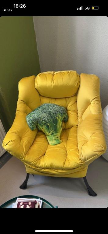 a green object sitting on a yellow couch at Modern 70m2 apartment in Jessheim