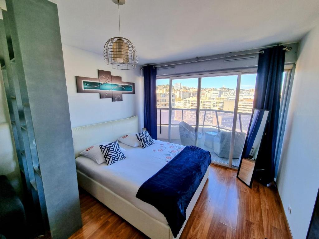 a bedroom with a bed and a large window at Appartement T1 Marseille Prado Chanot Plage in Marseille