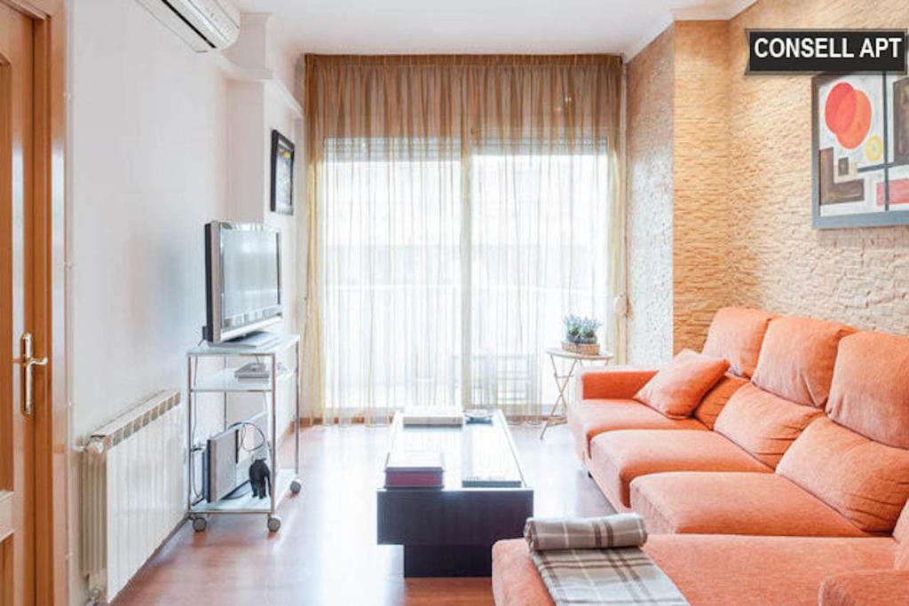 a living room with a couch and a television at Apartment Consell de Cent in Barcelona