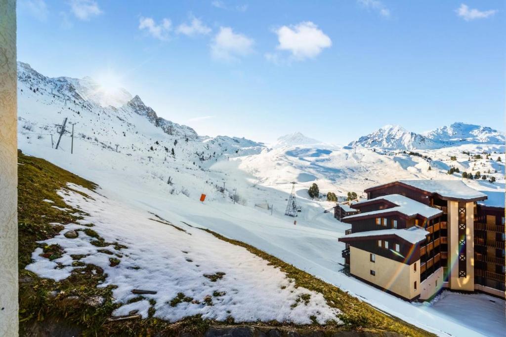 un lodge de ski dans les montagnes avec de la neige au sol dans l'établissement Résidence Les Néreïdes - maeva Home - 3 Pièces 7 Personnes Prestige MAE-3987, à La Plagne Tarentaise