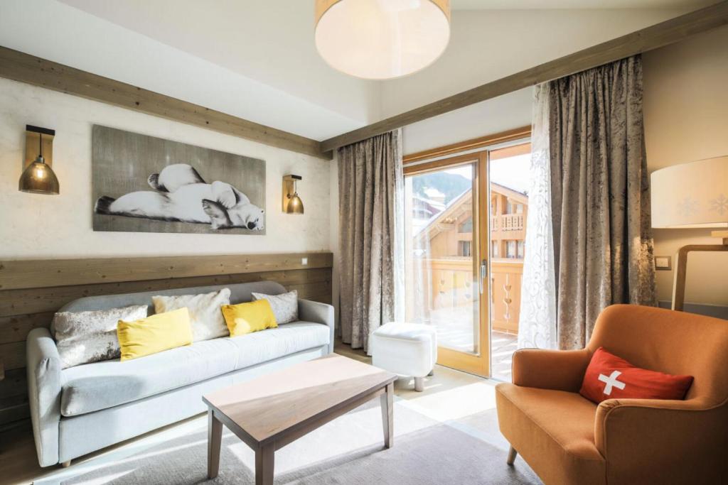 a living room with a couch and a chair at Résidence Premium L'Hévana - maeva Home - Appartement 3 pièces 6 personnes Prestige MAE-2293 in Les Allues